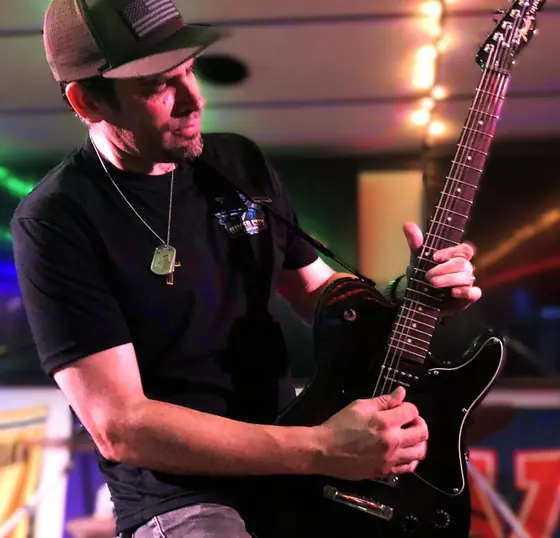Patrick Verdi of AUDIOVAULT playing guitar on stage